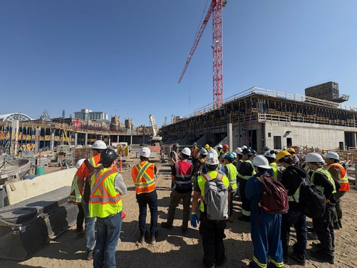 a group of SAIT students and instructors in personal protective equipment on the Taylor Family Campus Centre construction site