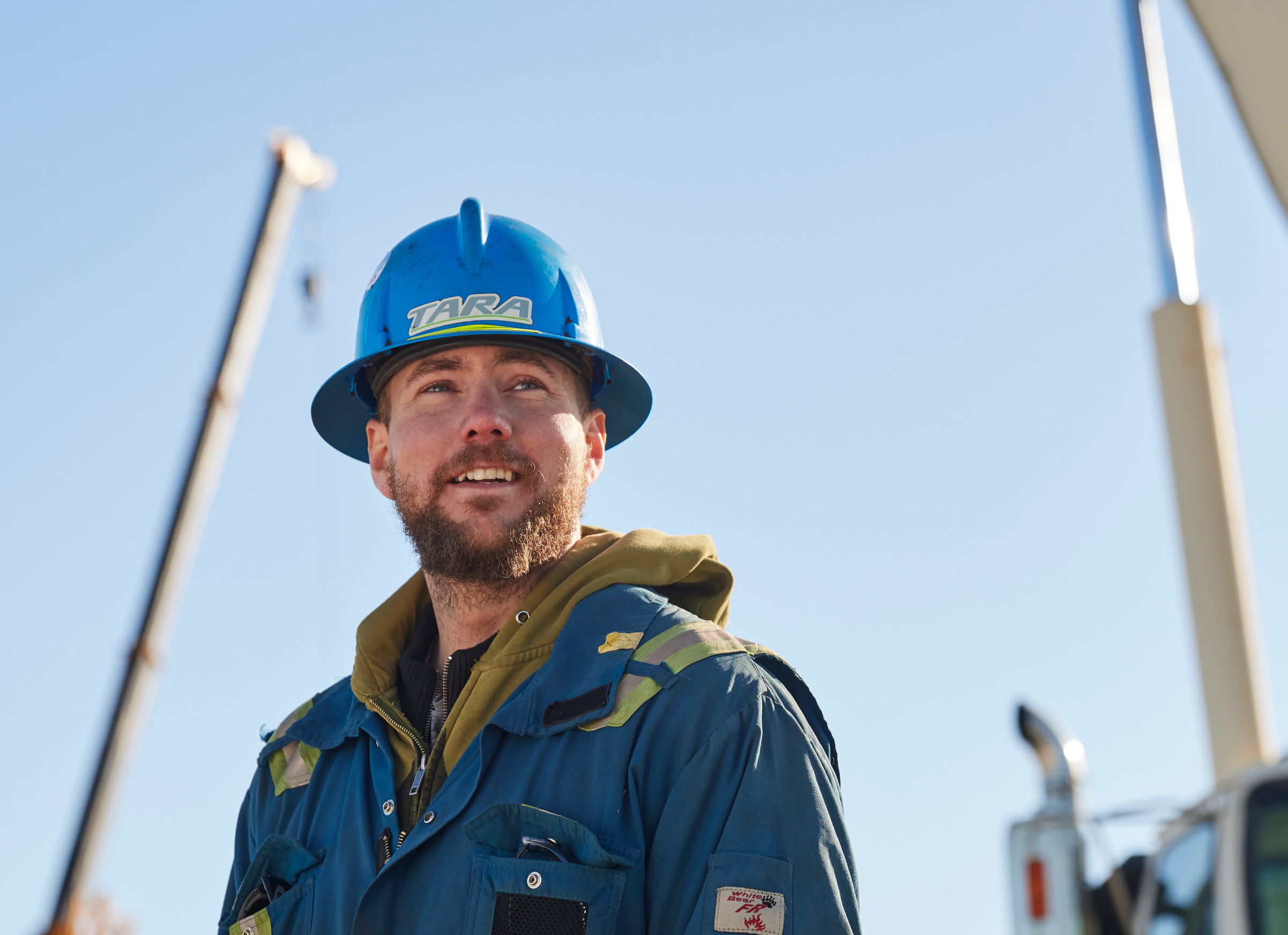 Man in hard hat outside smiling at camera