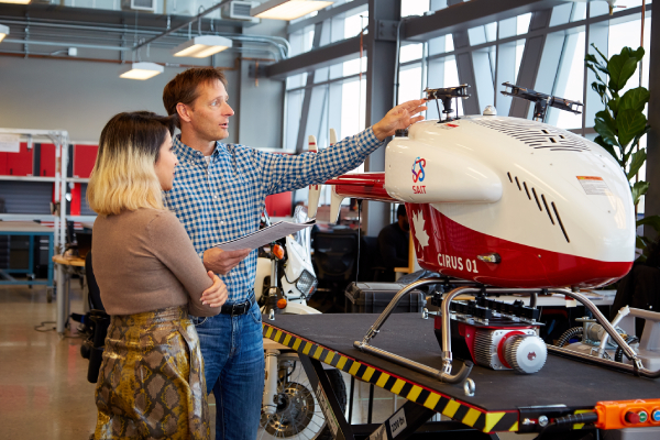 An ARIS researcher explains the mechanics of a drone to a student.