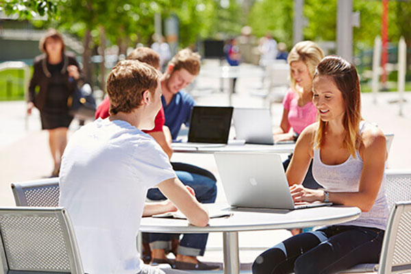 Students sitting in tables outdoors
