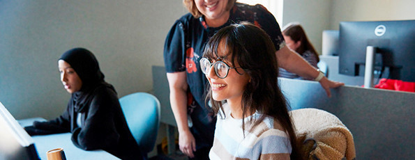 Students and instructors looking at a computer screen together.