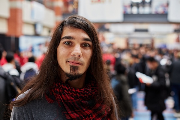 Student looking at the camera smiling holding a book