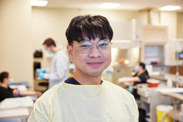 SAIT Medical student stands in lab and smiles at the camera