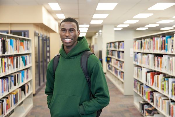 Student in the library smiles at camera