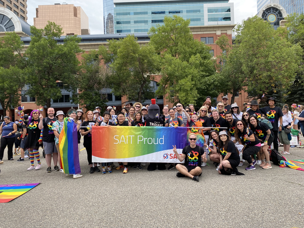 A group of SAIT students hold up a Pride flag.