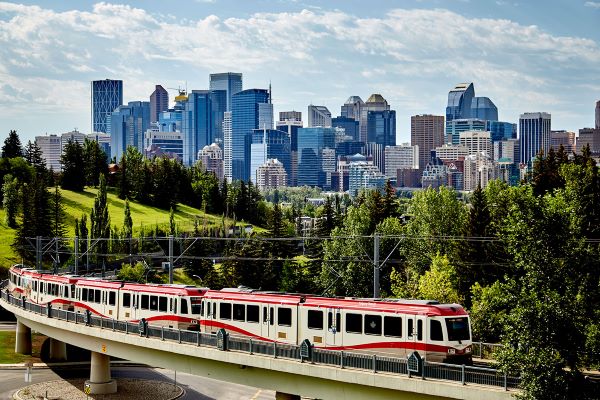 Train with greenery and buildings