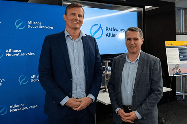 Wes Jickling and Ariel Torre stand in front of a background that says ‘Pathways Alliance’.