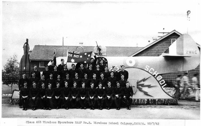 black and white archives photo of class 46B of the number 2 wireless operators - australian airmen in uniform in front of a float resembling an aircraft.