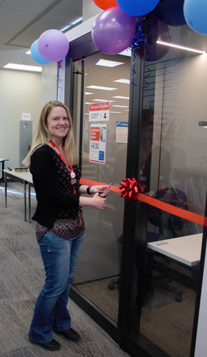 Photo of library staff cutting ribbon at grand opening of the individual study booth in the reg erhardt library in February 2025.