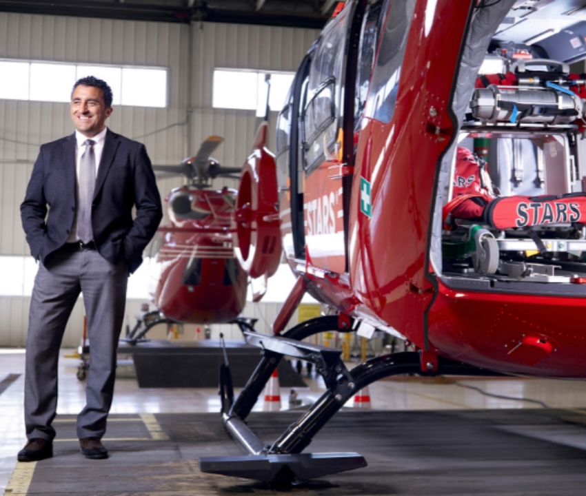 Mike Lamacchia stands beside stars helicopter