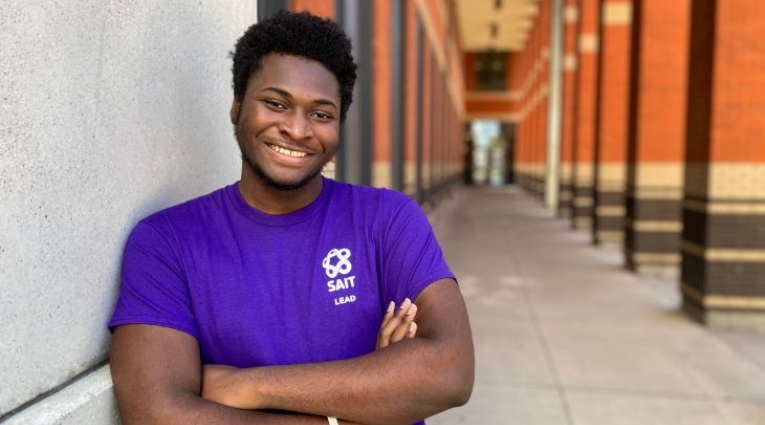 Young black male wearing a purple shirt smiling