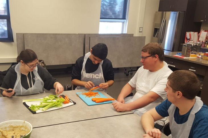 students at table with food preparation