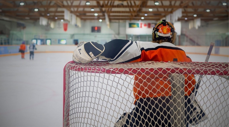 photo of the back of a goalie in a net on the ice