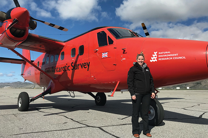 Jen Erickson standing in front of a red plane