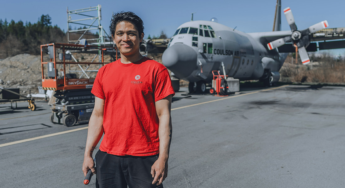 Filipino man standing in front of a plane outside