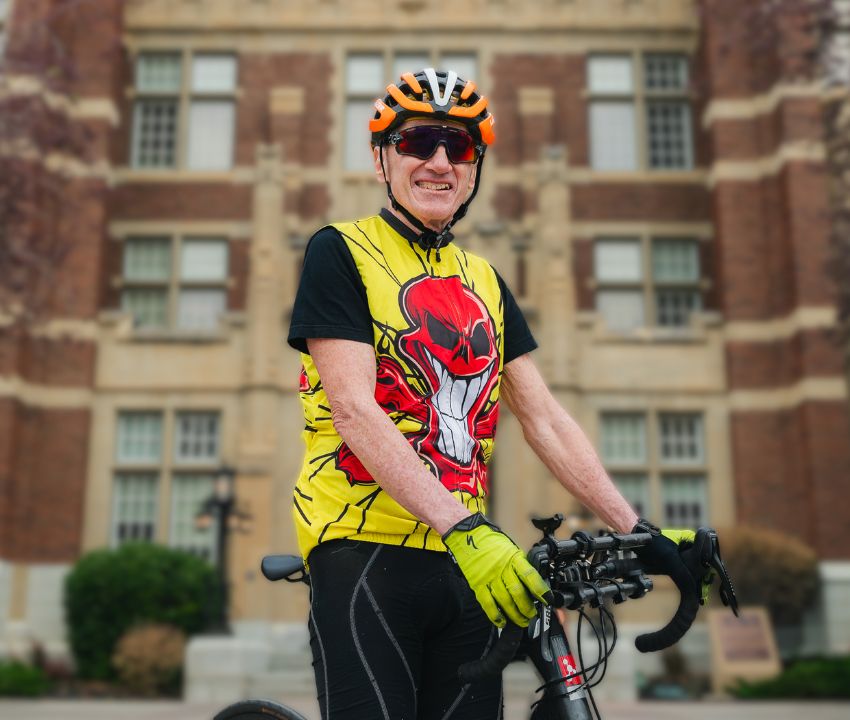 Mature male in bicycle gear in front of a building