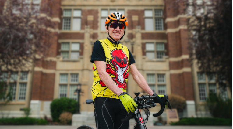 Mature male in bicycle gear in front of a building