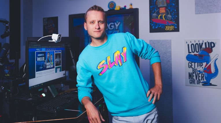 photo of young man in blue sweater with the word slay on the front