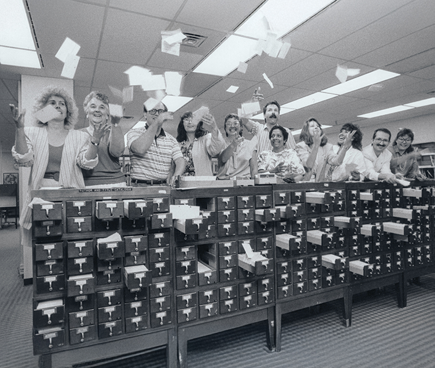 Archival photo of library staff throwing cards in the air