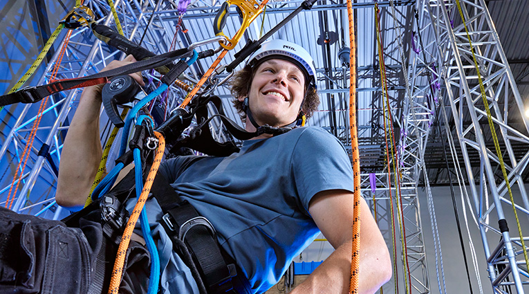 Young man training on ropes in a building