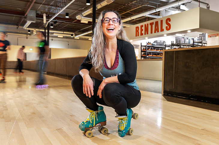 Young woman squatting while wearing rollerskates