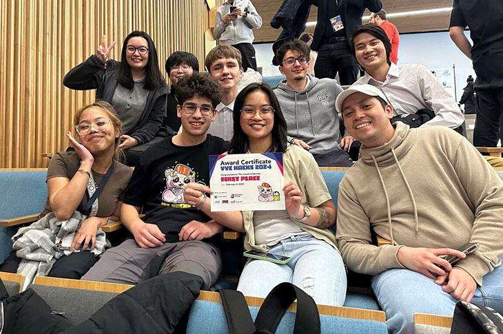 group of students in a lecture theatre celebrating at YYC Hacks event