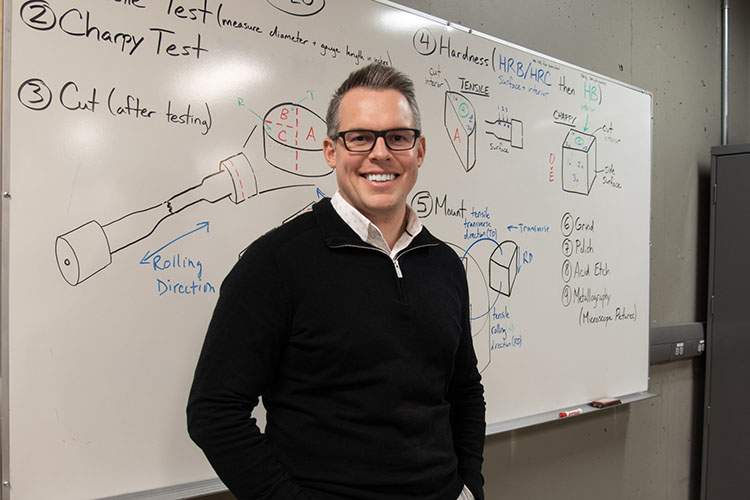 Josh Brewster, SAIT's Interim Associate Dean of the School of Manufacturing and Automation stands in front of a whiteboard in the metallurgy lab.