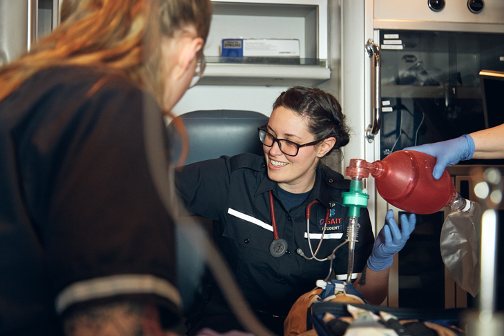 Three paramedic students training in an ambulance