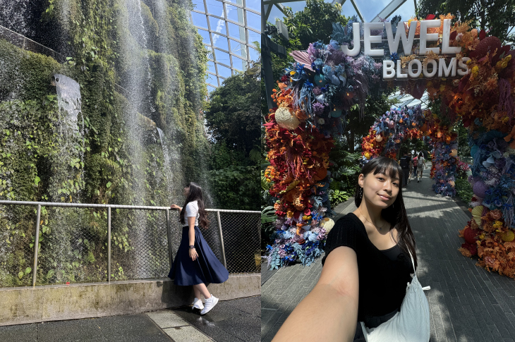 Mae stands in front of an indoor waterfall and poses for a selfie in front of a flower garden at the airport.