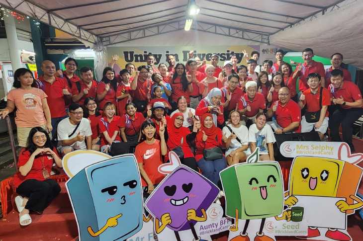 A large group of people, including SAIT students, pose for a Racial Harmony Day community event.