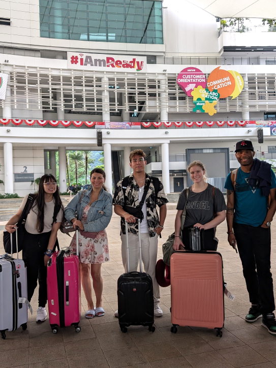 Five SAIT students stand behind their luggage at the ITE College West campus.