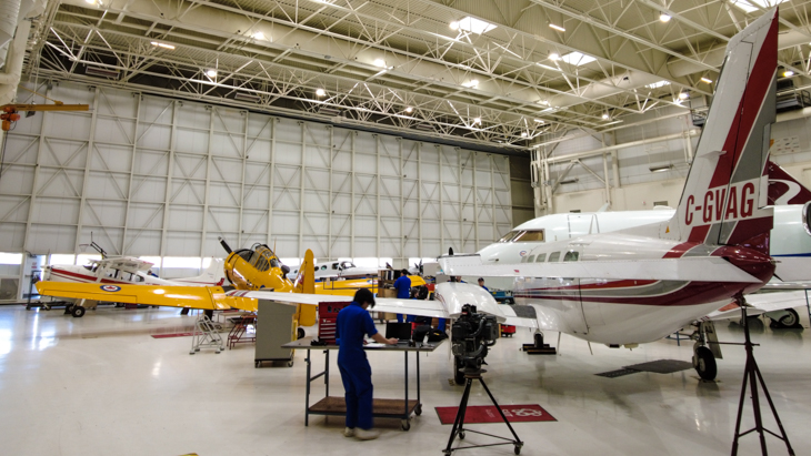 Art Smith Aero Centre's hanger with airplanes and a student