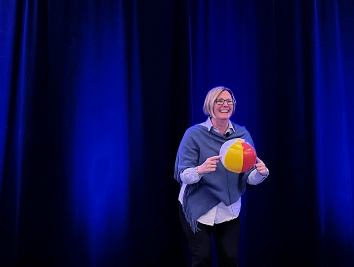 A person on stage holding a beach ball