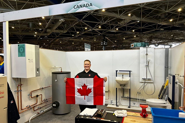 Noah Harding at WorldSkills holding a flag