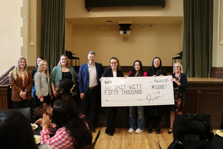 A group of people presenting a large cheque