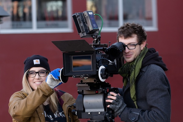 Two students with a professional video camera