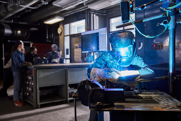 A welding student works in a welding lab.
